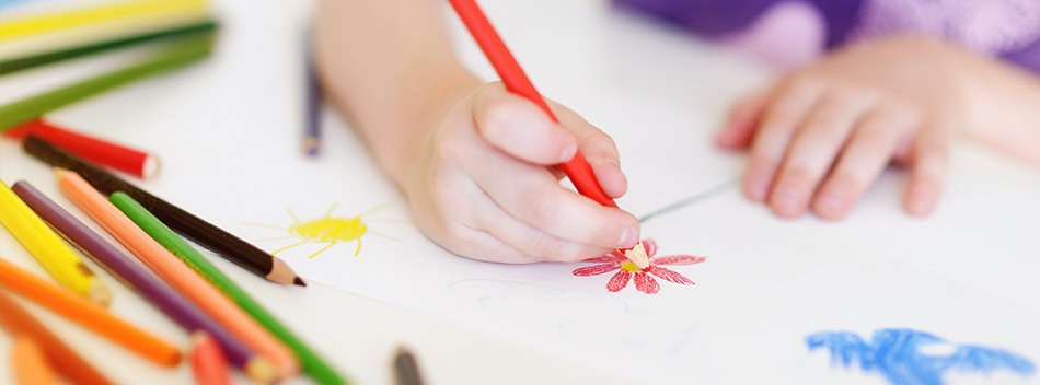 a child drawing flowers with colored pencils 